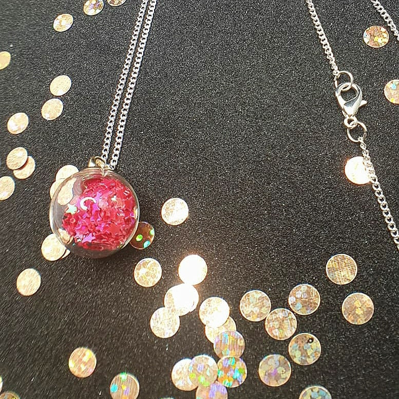 Glass ball pendant necklaces filled with star shaped glitter available in a variety of colours with either holographic or iridescent star shaped glitter